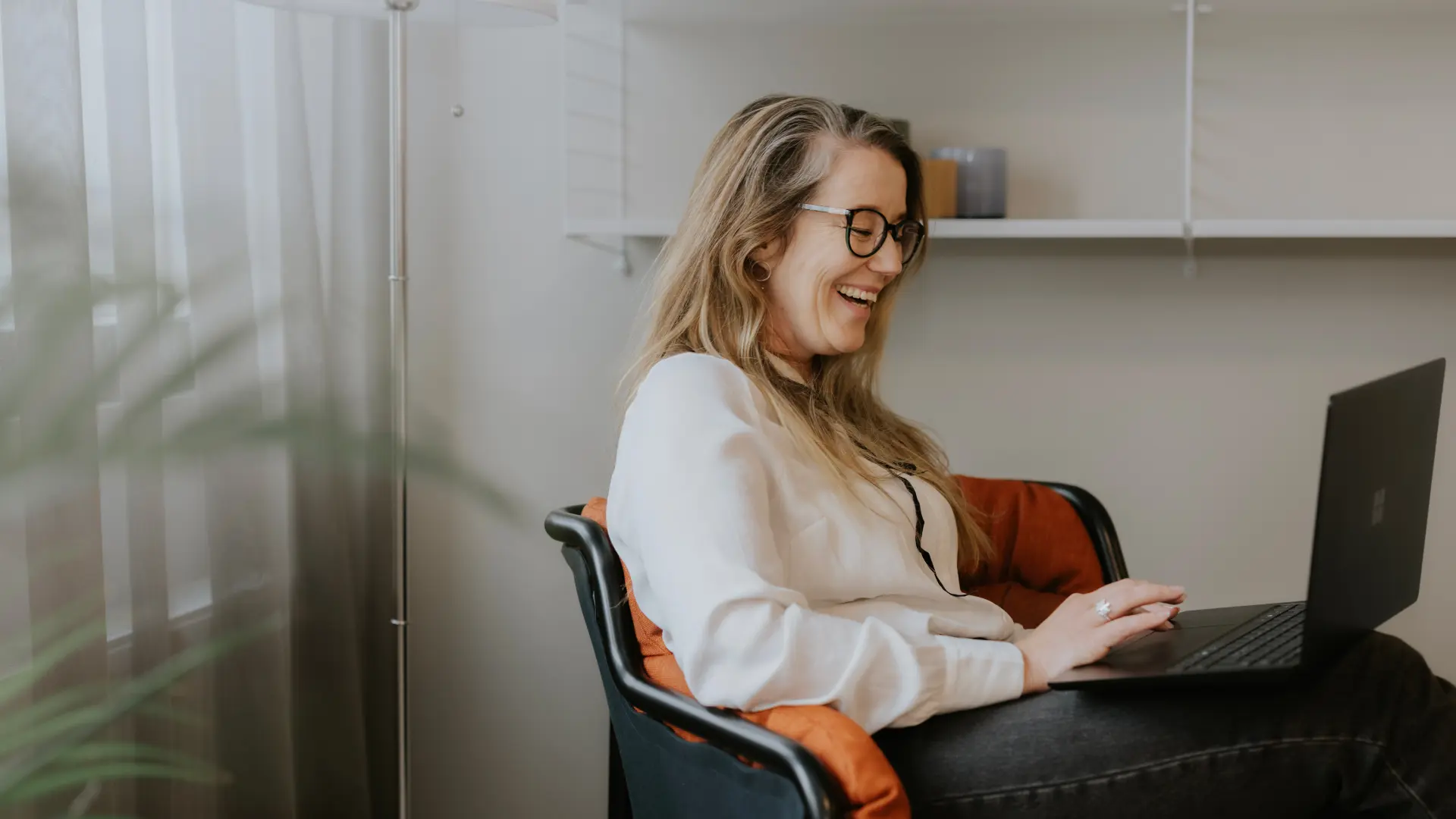 Leende kvinna arbetar i Business Central för att planera och optimera tillverkningsprocessen