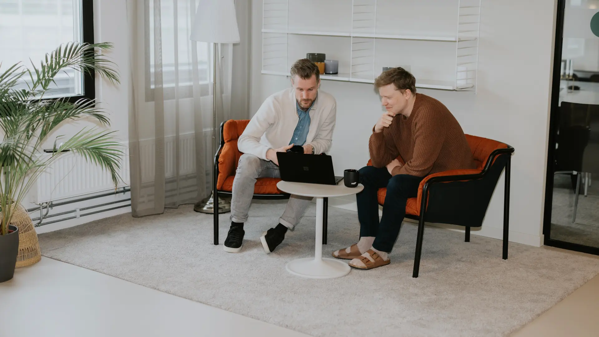 Två medarbetare planerar produktionskapacitet i Business Central på laptop